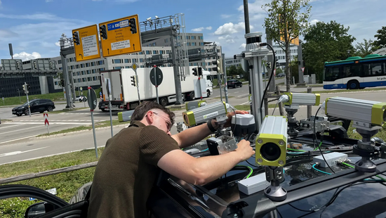 TUM-Forscher Erik Leo Haß prüft die Sensorik auf dem Fahrzeug an einer Kreuzung in Garching-Hochbrück. Bild: Schmitz / TUM TUM-Forscher Erik Leo Haß prüft die Sensorik auf dem Fahrzeug an einer Kreuzung in Garching-Hochbrück. Bild: Schmitz / TUM